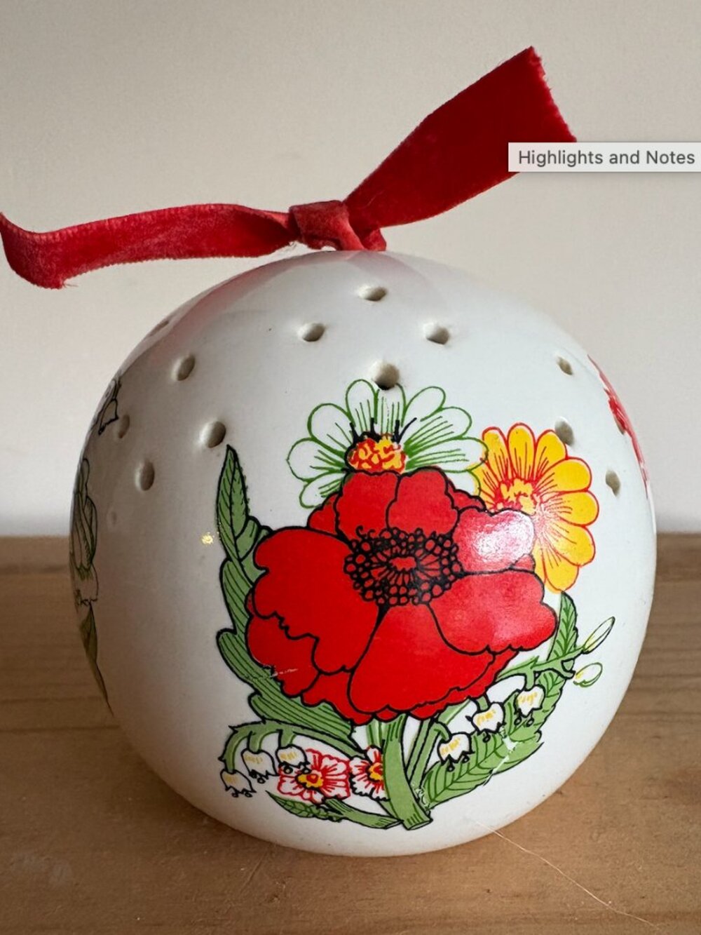 Vintage round ceramic pomander featuring a detailed botanical design of color